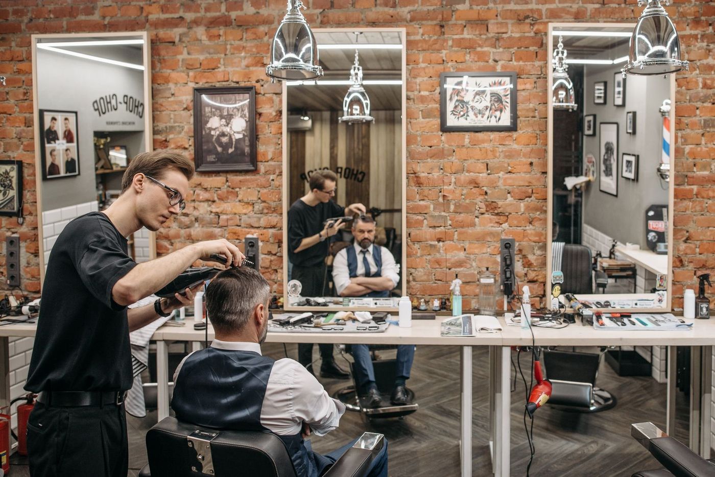 A barber cutting a client's hair in a barbershop