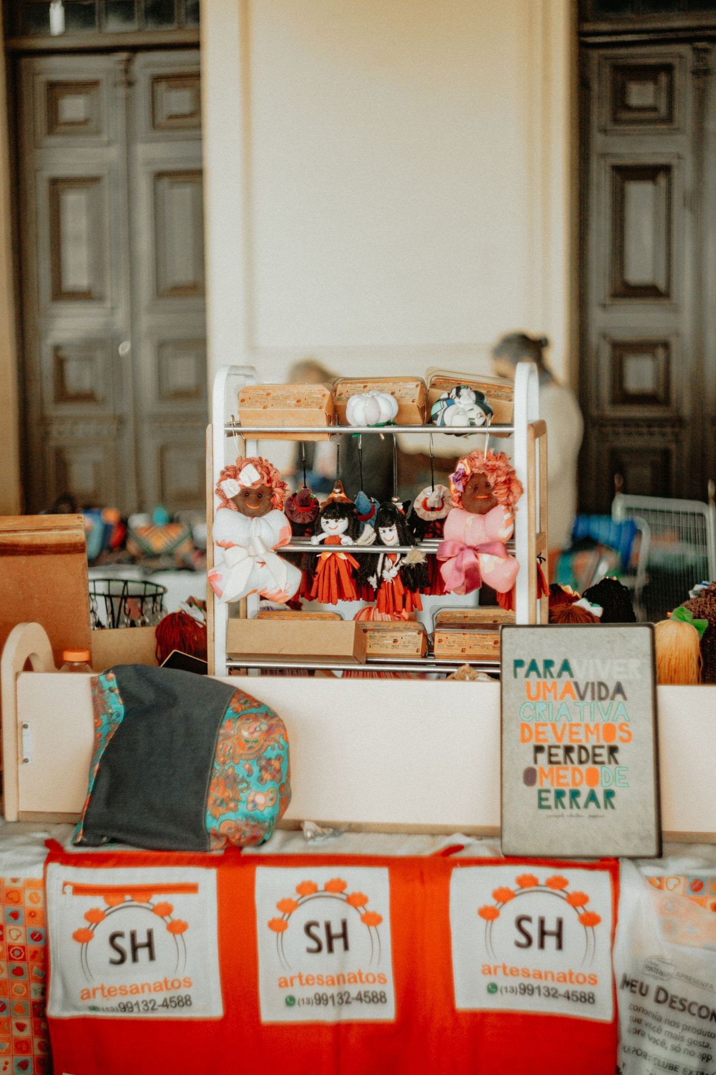 A craft market stall with handmade goods and a seller