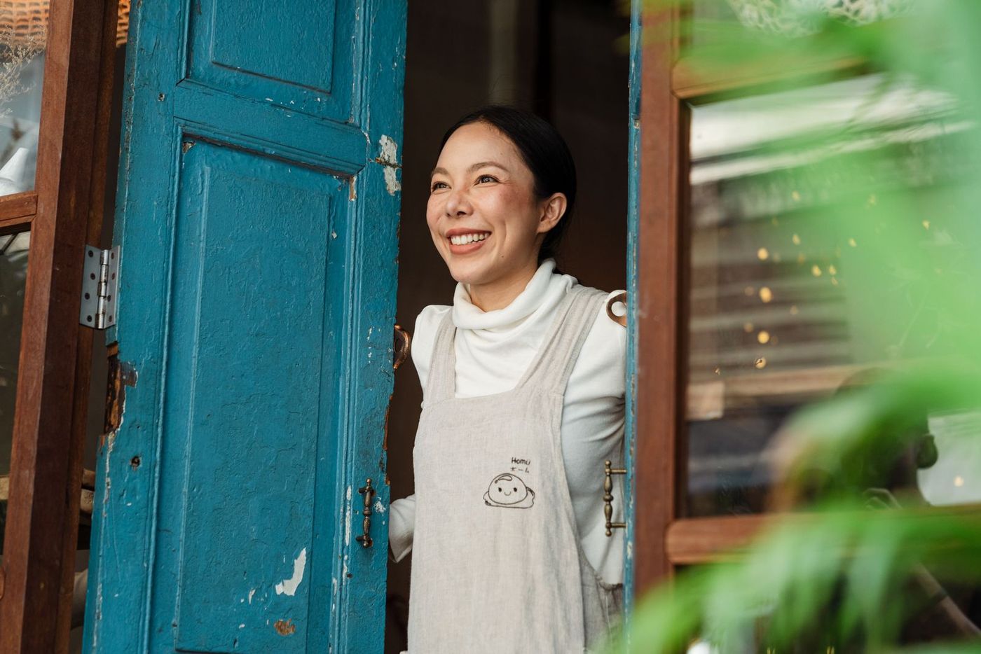 An independent business owner standing in the open doorway of her own shop
