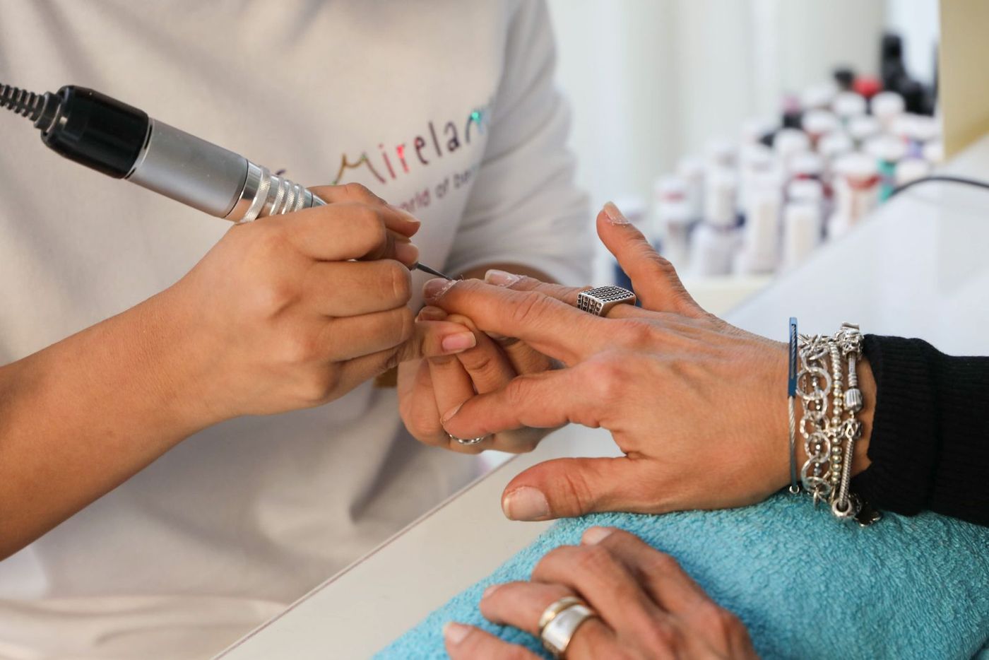 A nail technician working on a client's manicure