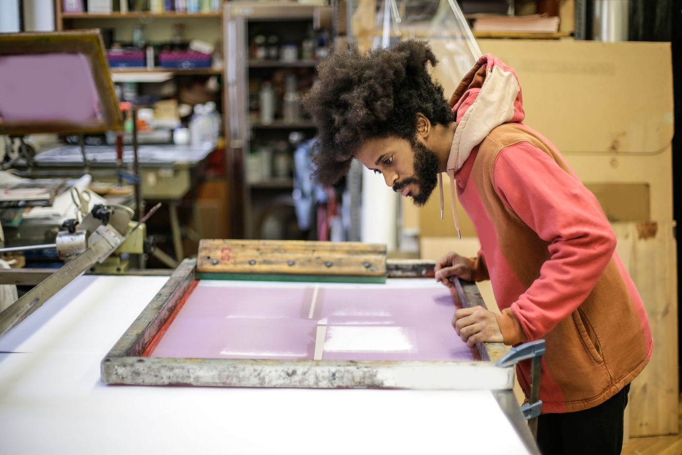 A craftsperson screen printing garments in a workshop